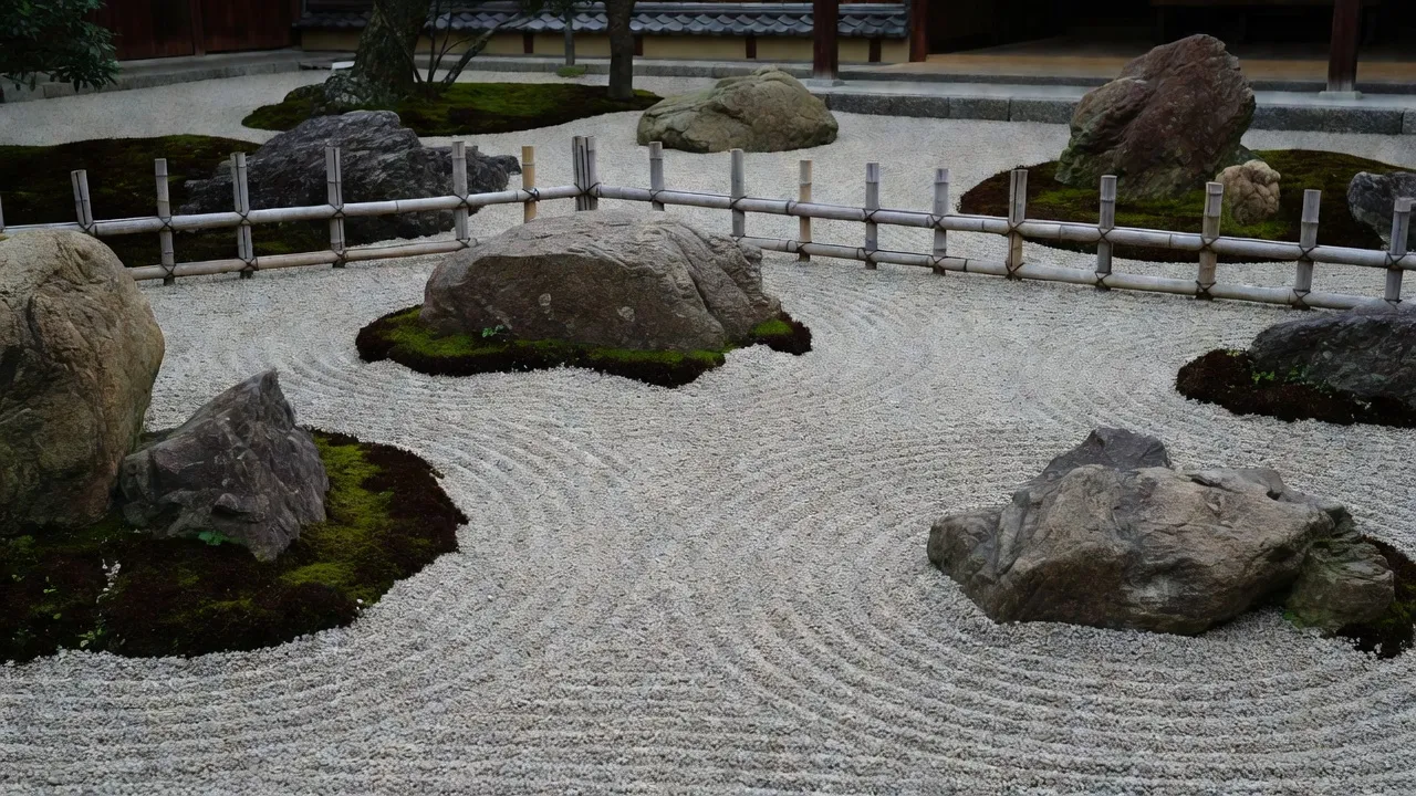 Traditional Japanese karesansui dry garden with raked gravel and mossy stones